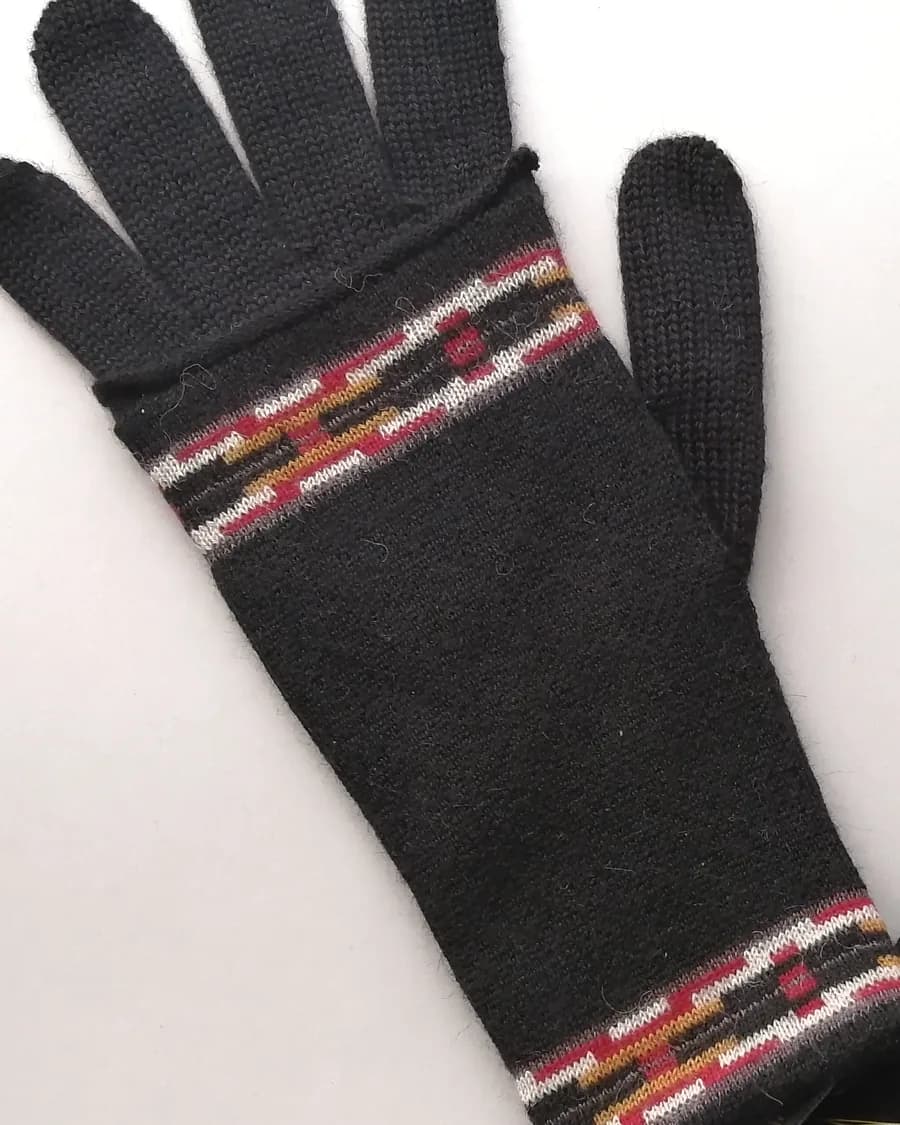 Guante en baby alpaca gris oscuro, con una franja de motivos andinos en el puño.