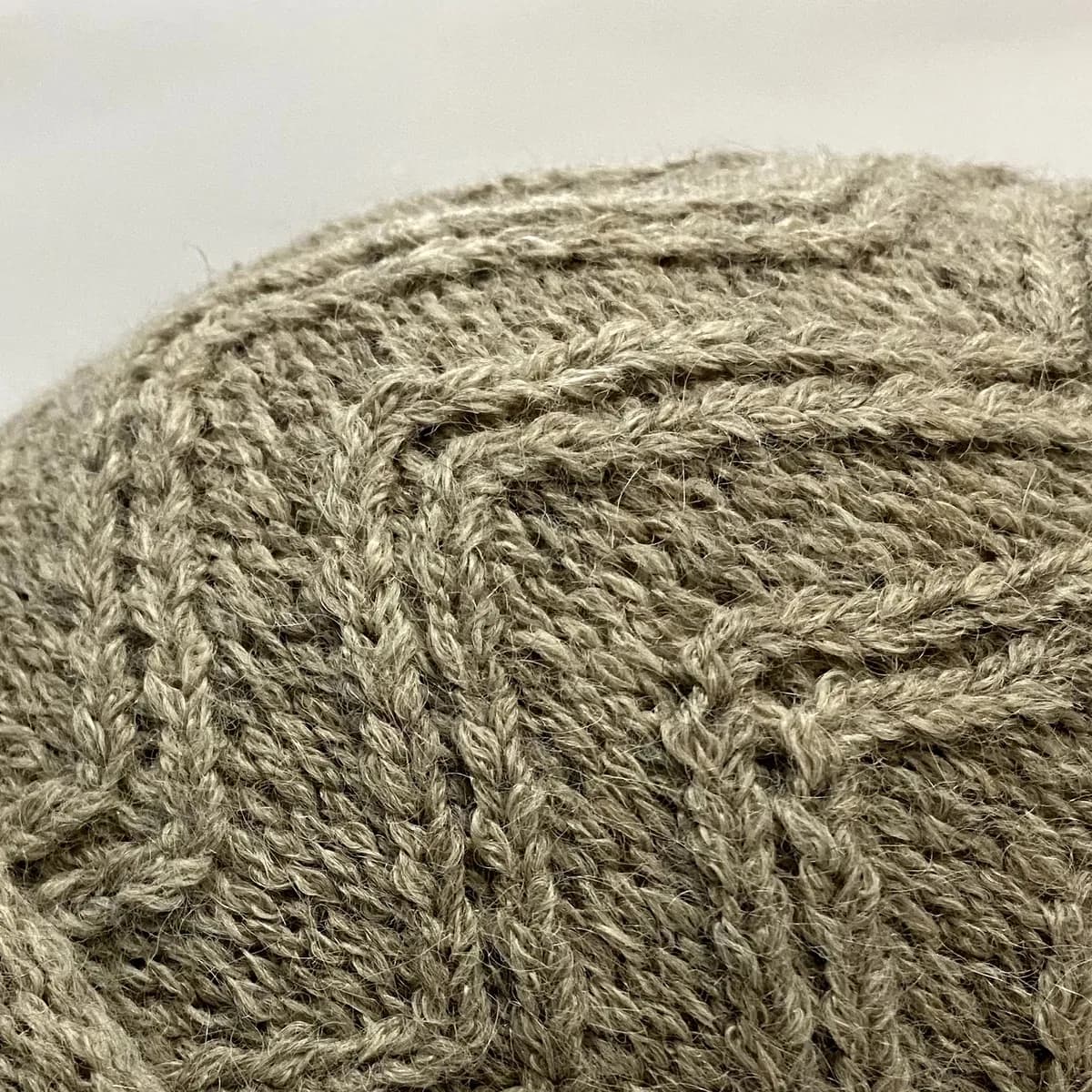 Detalle del punto en zigzag de un gorro tejido en alpaca beige natural.