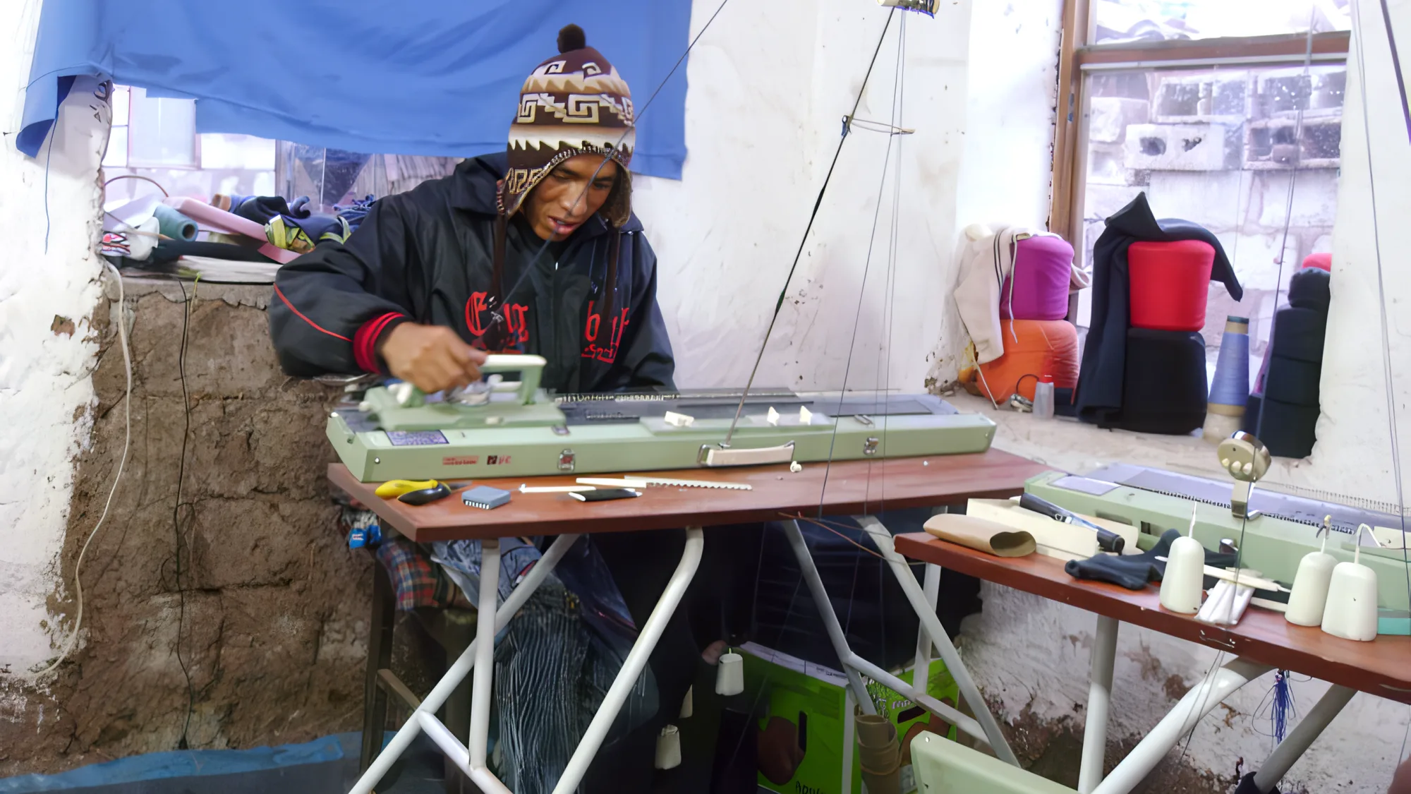 Un tejedor de Awasqa Boni trabajando en una máquina rectilínea manual.