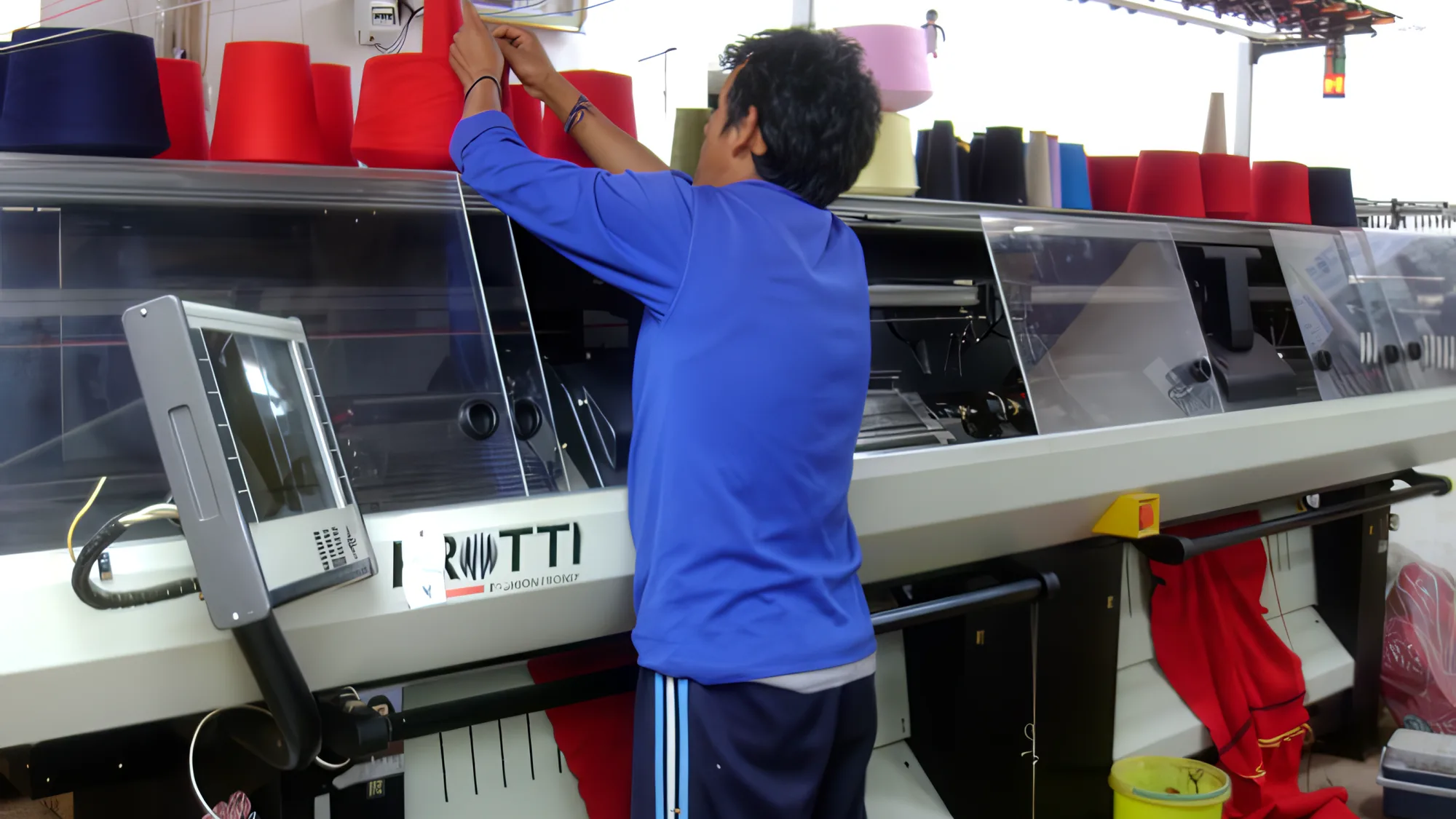 El taller de Awasqa Boni en Andahuaylillas, con la máquina rectilínea y los conos de hilado.